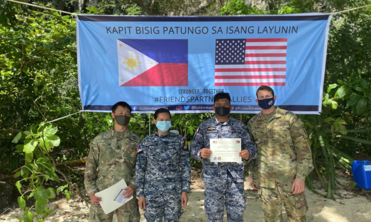 U.S. service personnel with the Coast Guard Station El Nido Commander and a student during training graduation.
