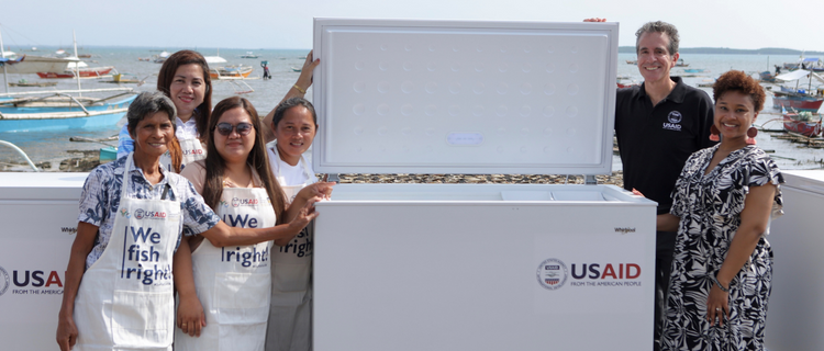 Group of people with one of the donated freezers.