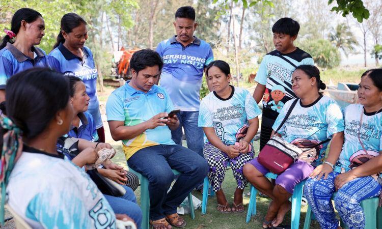 Group of people with one person holding a smartphone.