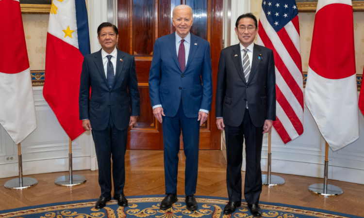 President Ferdinand R. Marcos Jr., President Joe Biden, and Prime Minister Fumio Kishida standing in front of flags of the United States, Japan, and the Philippines inside the White House.