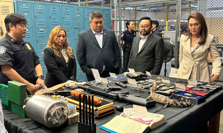 A United States Customs and Border Protection (CBP) officer shows Philippine customs officials items confiscated at the Los Angeles International Mail Facility (IMF).