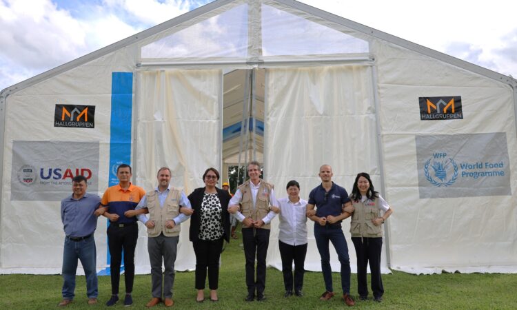 USAID Mission Director Ryan Washburn (fifth from left) and Cagayan Provincial Administrator Atty. Maria Rosario Mamba-Villaflor (fourth from left) with provincial government staff stand in front of a mobile storage unit handed over by USAID and the World Food Programme.