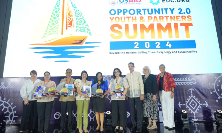 United States Agency for International Development (USAID) Philippines Mission Director Ryan Washburn (third from right) and USAID Opportunity 2.0 Chief of Party Jill Jarvi (leftmost) pose onstage with officials of the Department of Education (DepEd), Technical Education and Skills Development Authority (TESDA), Department of Trade and Industry (DTI), National Youth Commission, and Education Development Center.