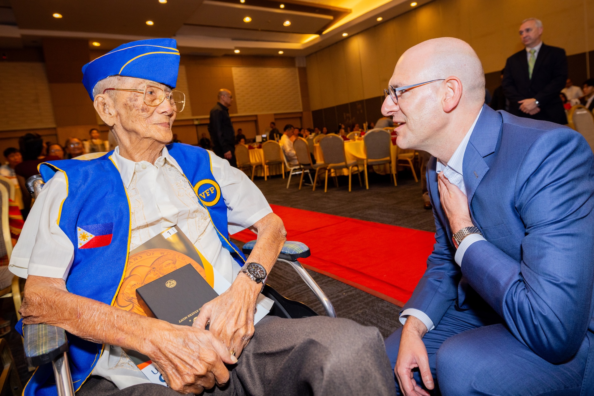 Chargé d’Affaires, a.i., Y. Robert Ewing speaks with Sgt. Alfredo de Leon del Rosario at the Congressional Gold Medal awarding ceremony in Tagum.